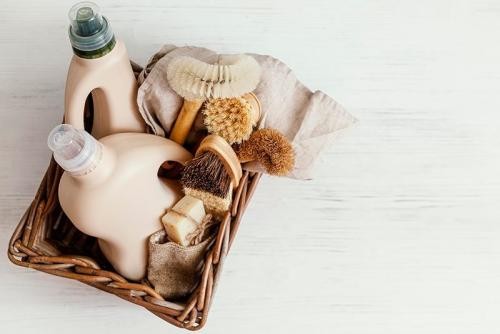 Holzbürsten und Reinigungsflaschen in Holzkorb